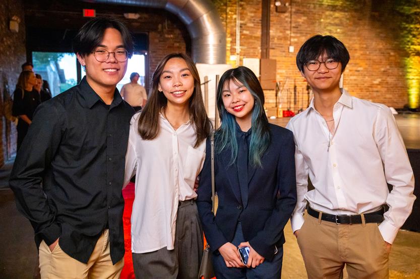 A group of four students smiles